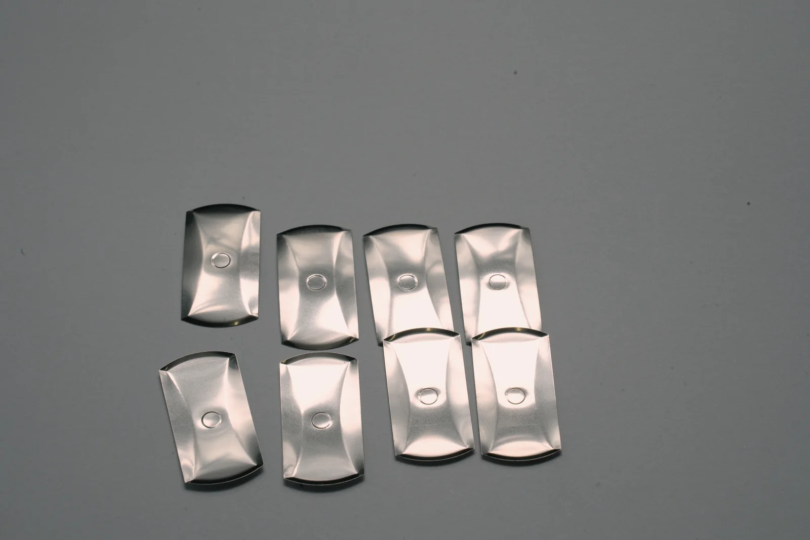 Oblong metal dome components arranged for geometry comparison